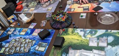 Photo of an ongoing game of Commander in which every player has an absurd number of lands for an indiscernible reason.